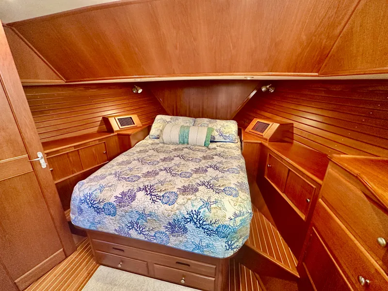 Slide: The Image of Luxurious cabin interior of 2001 Grand Banks 49 Eastbay HX with wood finish and cozy bedding. - 28