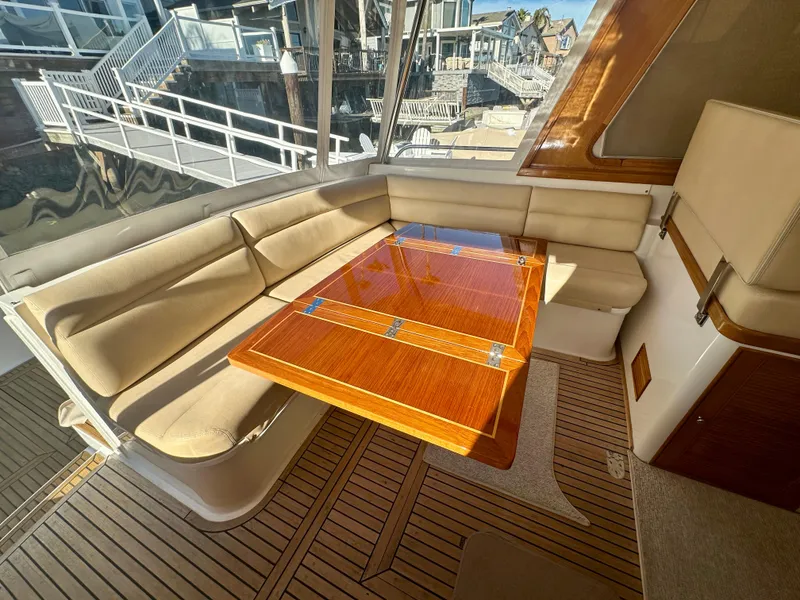 Slide: The Image of 2001 Grand Banks 49 Eastbay HX interior with elegant wood table and beige seating. - 36