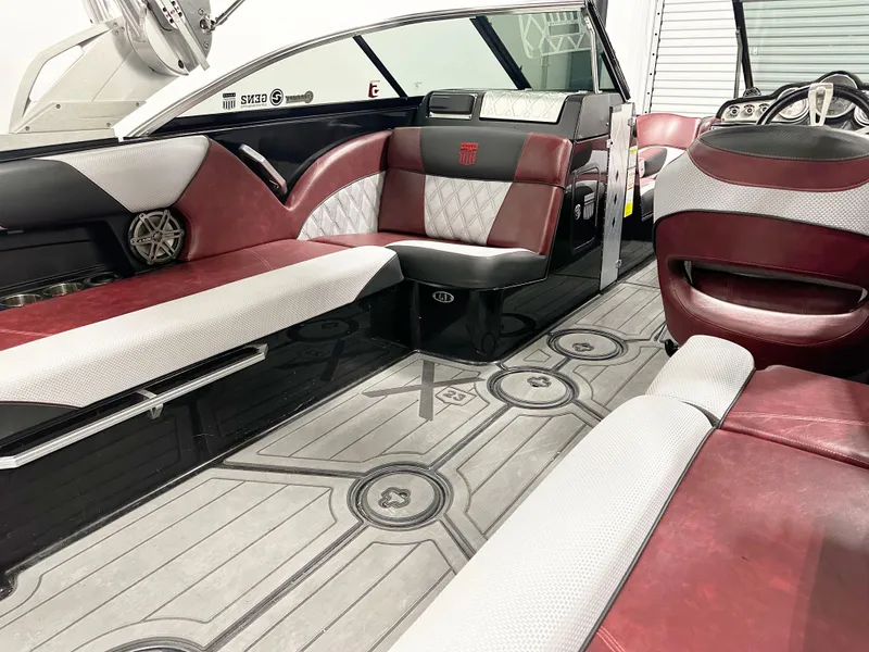 Slide: The Image of 2015 MasterCraft X23 boat interior with red and white seating, modern design, and sleek flooring. - 6