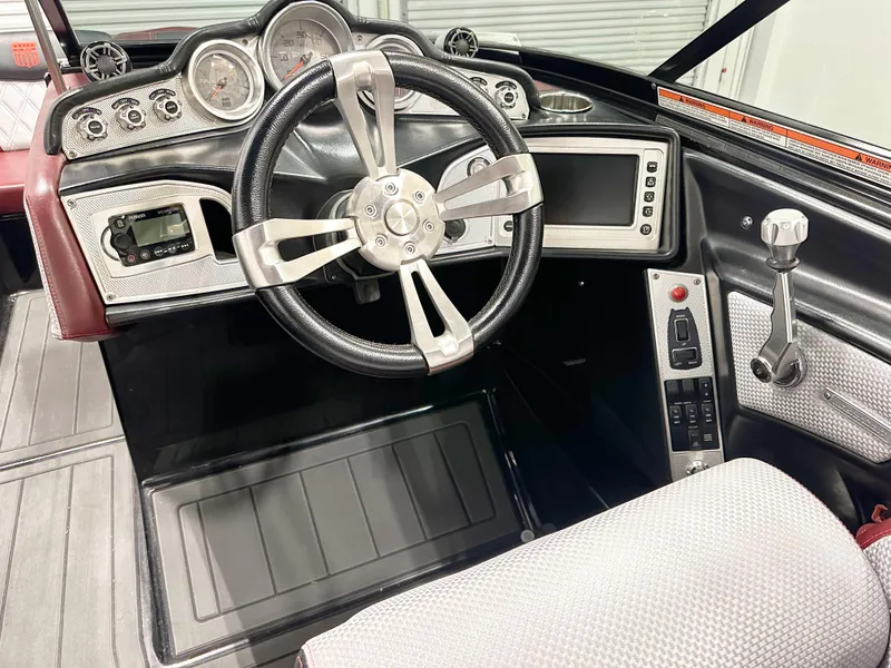 Slide: The Image of 2015 MasterCraft X23 boat dashboard with steering wheel and control panel. - 7