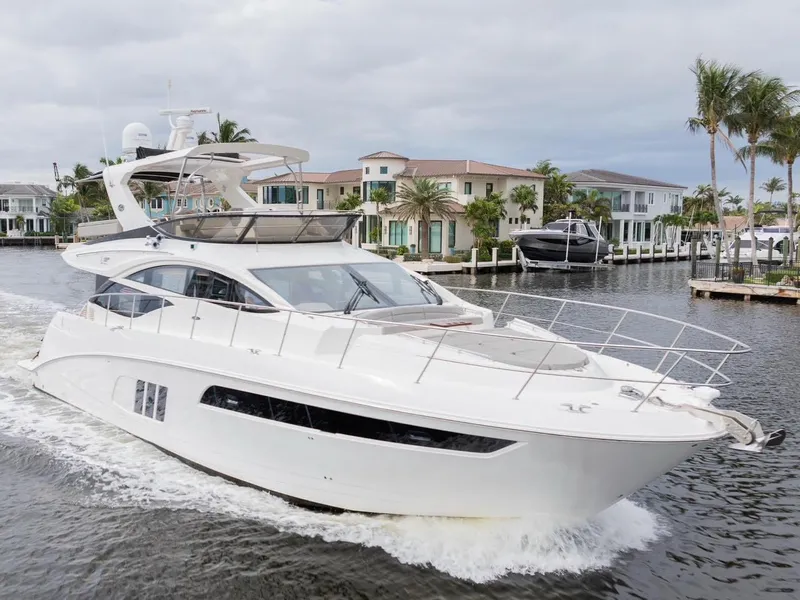 Slide: The Image of 2017 Sea Ray 59 Flybridge yacht cruising near waterfront homes. - 2