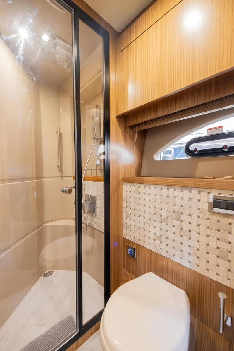 Slide: The Image of Luxurious bathroom in 2017 Sea Ray 59 Flybridge yacht with modern shower and wooden accents. - 25
