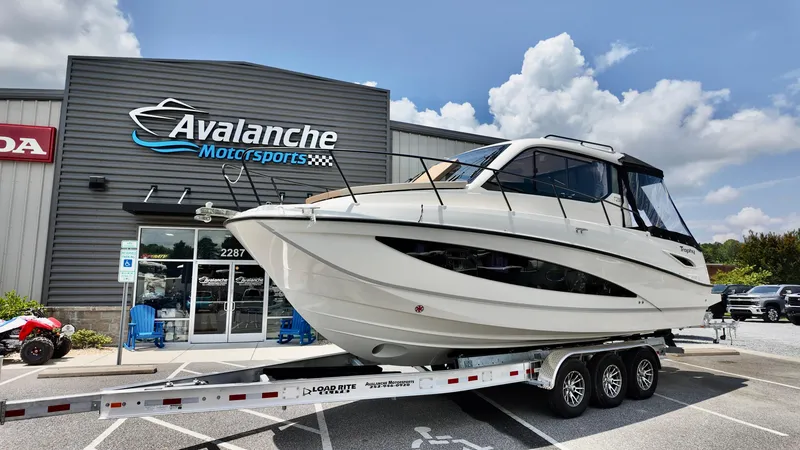 Slide: The Image of 2025 Bayliner Trophy 29 Explorer boat on trailer at Avalanche Motorsports dealership. - 0
