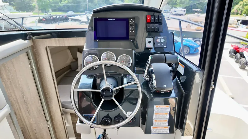 Slide: The Image of 2025 Bayliner Trophy 29 Explorer helm with steering wheel and navigation controls. - 29