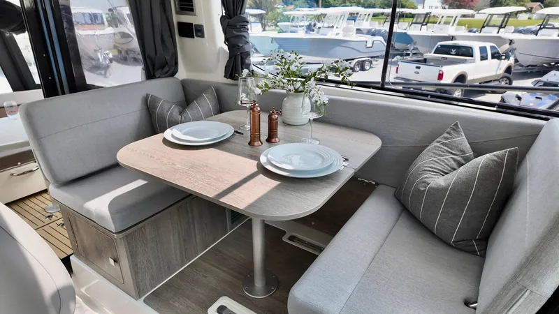 Slide: The Image of 2025 Bayliner Trophy 29 Explorer interior with cozy dining area and elegant table setting. - 5