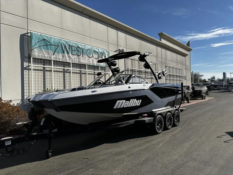 The Image of 2025 Malibu Wakesetter 24 MXZ boat on trailer outside dealership. - 0