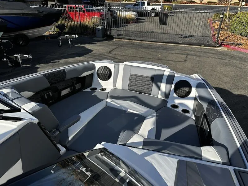 Slide: The Image of 2025 Malibu Wakesetter 24 MXZ boat interior with gray seating and cup holders. - 8