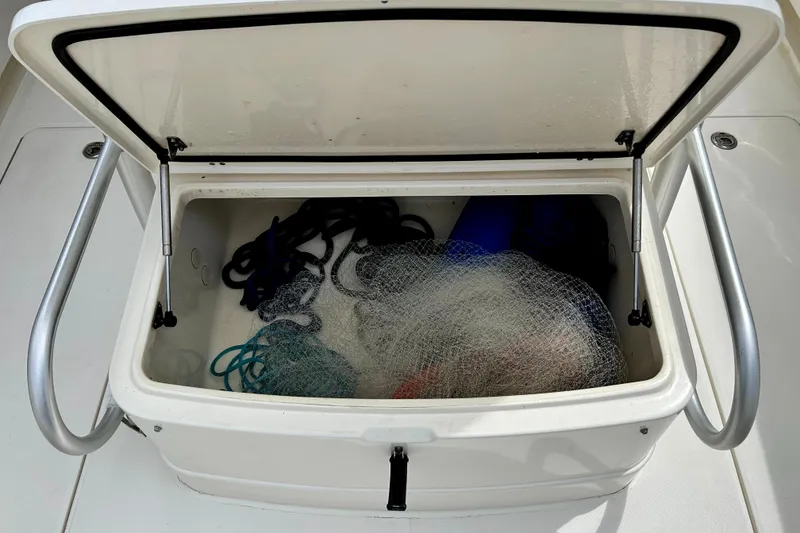 Slide: The Image of Open storage compartment on 2008 World Cat 330 TE boat with fishing gear inside. - 12