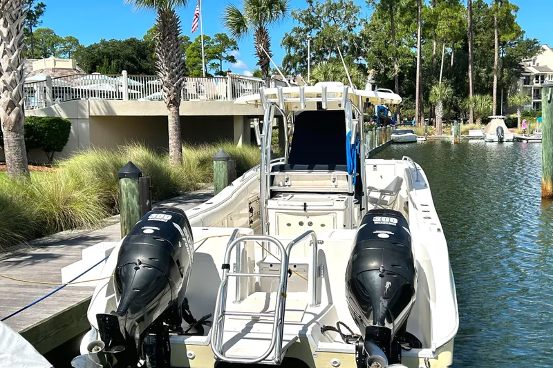 Slide: The Image of 2008 World Cat 330 TE boat docked with dual engines, surrounded by palm trees and calm water. - 2