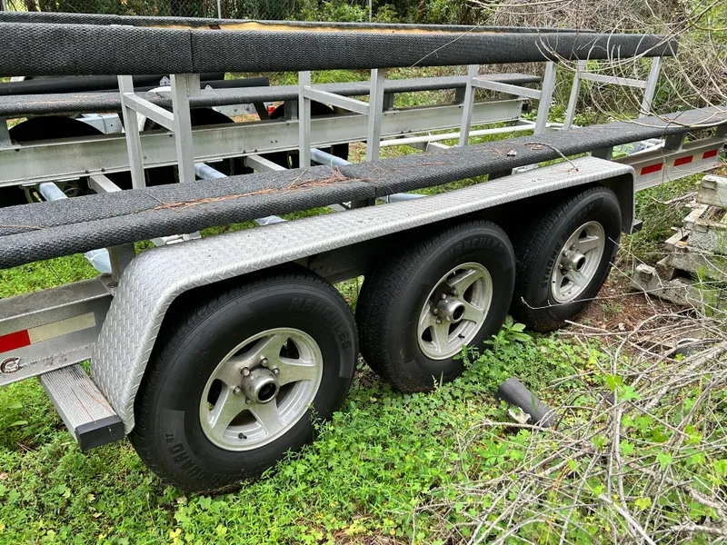 Slide: The Image of Triple-axle boat trailer for 2008 World Cat 330 TE, parked on grass. - 32