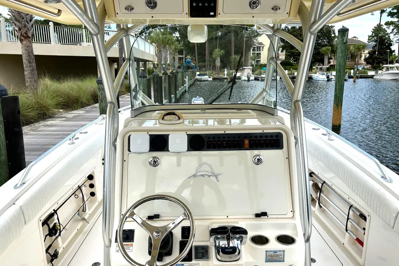 Slide: The Image of 2008 World Cat 330 TE boat cockpit with steering wheel and control panel, docked by a canal. - 4