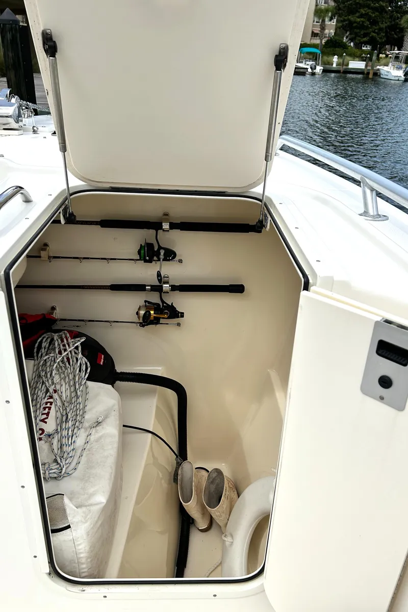 Slide: The Image of Open storage compartment on 2008 World Cat 330 TE boat with fishing rods and gear. - 9