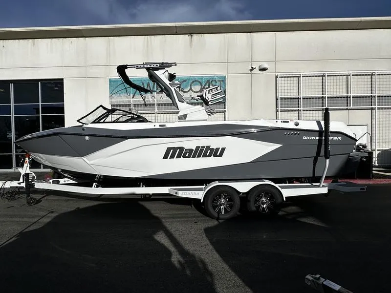 The Image of 2025 Malibu Wakesetter 26 LSV boat on trailer, parked outside a building. - 0