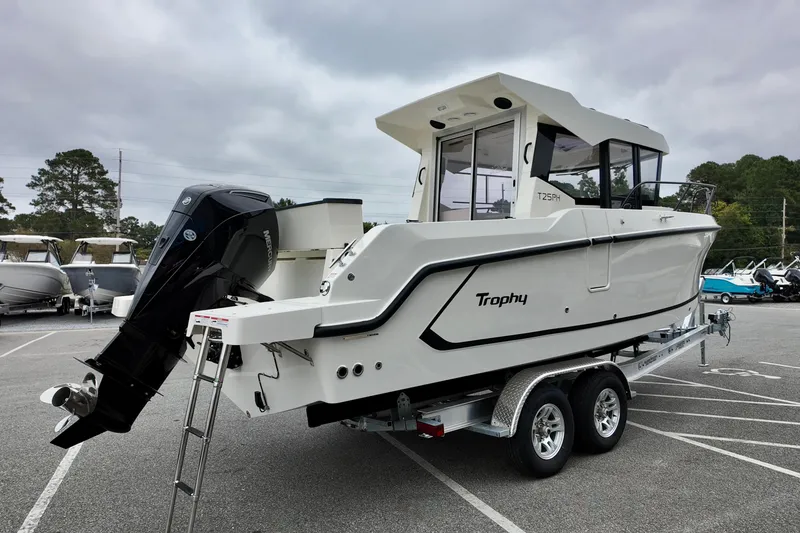Slide: The Image of 2026 Bayliner Trophy T25 Pilothouse boat on trailer in parking lot. - 5