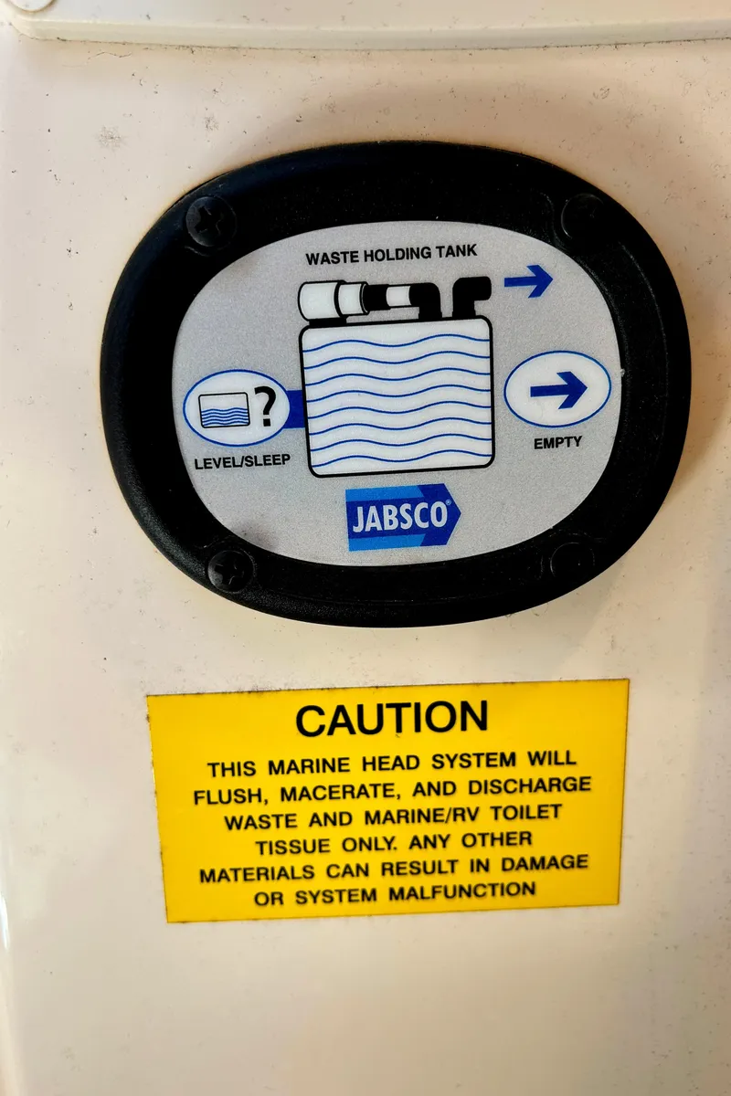 Slide: The Image of 2020 Grady-White Freedom 275 waste tank gauge with caution label for marine head system. - 26