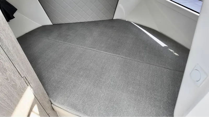 Slide: The Image of 2025 Bayliner TROPHY 25 EXPLORER cabin interior with gray cushioned seating. - 10