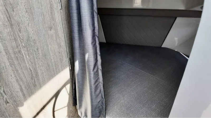 Slide: The Image of Interior cabin of 2025 Bayliner TROPHY 25 EXPLORER with gray upholstery and curtain. - 13