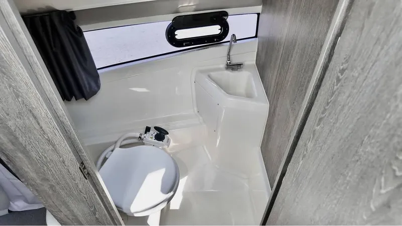 Slide: The Image of 2025 Bayliner TROPHY 25 EXPLORER boat bathroom with toilet and sink. - 14