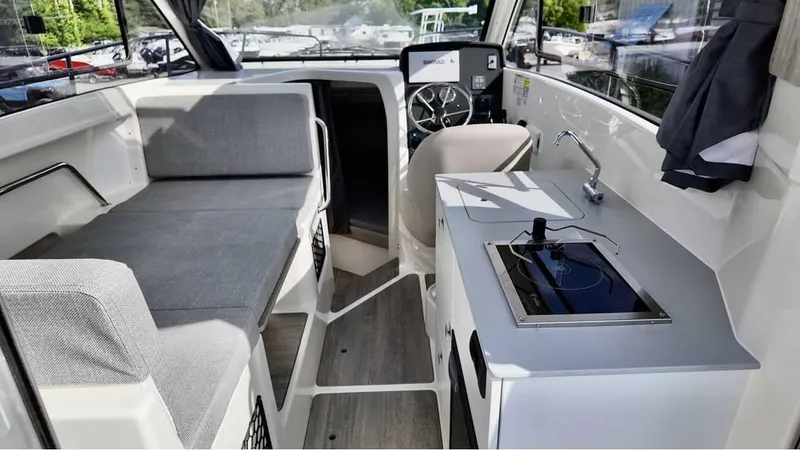 Slide: The Image of 2025 Bayliner TROPHY 25 EXPLORER interior with seating, helm, and kitchenette. - 15