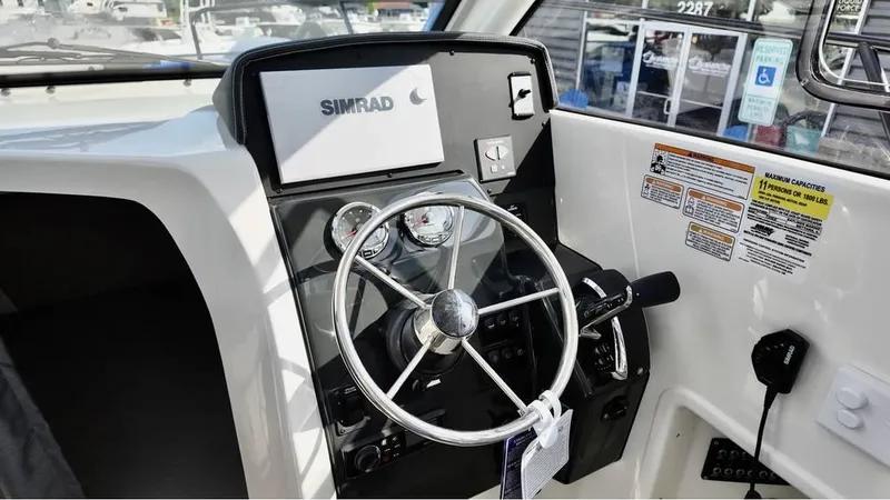 Slide: The Image of 2025 Bayliner TROPHY 25 EXPLORER helm with Simrad navigation system and steering wheel. - 16
