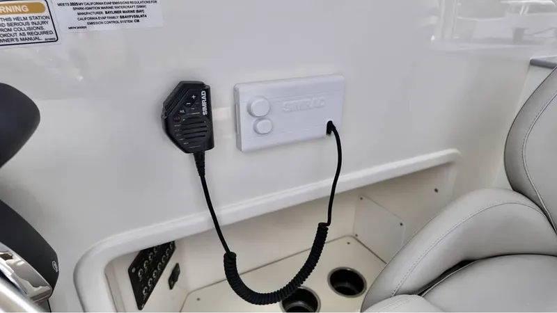 Slide: The Image of 2025 Bayliner TROPHY 25 EXPLORER interior with radio microphone and control panel. - 18