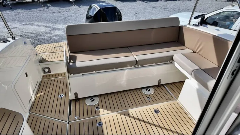 Slide: The Image of 2025 Bayliner TROPHY 25 EXPLORER boat interior with cushioned seating and teak flooring. - 22