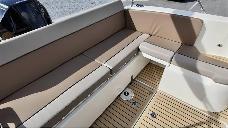 Slide: The Image of 2025 Bayliner TROPHY 25 EXPLORER boat interior with beige seating and wooden flooring. - 23