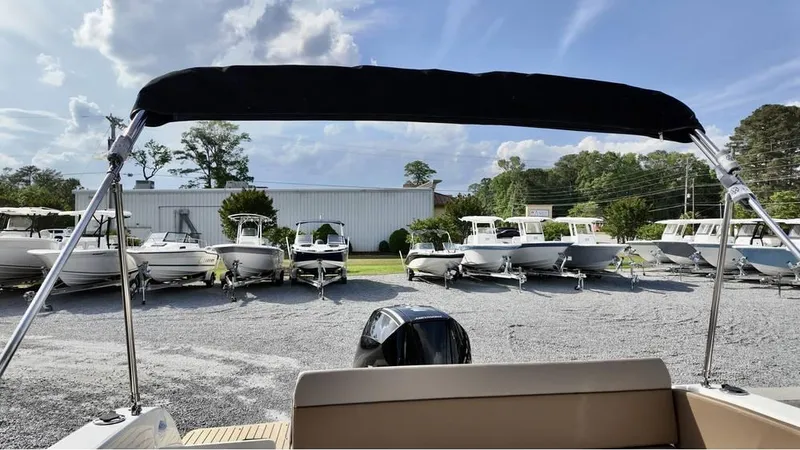 Slide: The Image of 2025 Bayliner TROPHY 25 EXPLORER boat in a dealership lot under a sunny sky. - 24