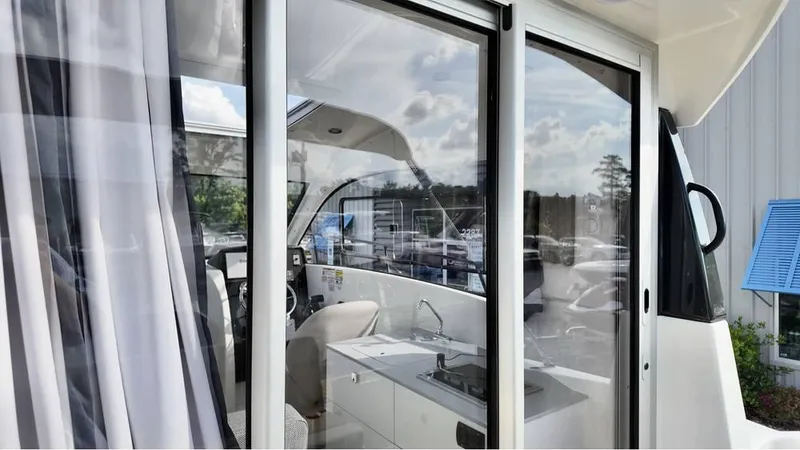 Slide: The Image of 2025 Bayliner TROPHY 25 EXPLORER interior view through glass doors, showcasing sleek design. - 26