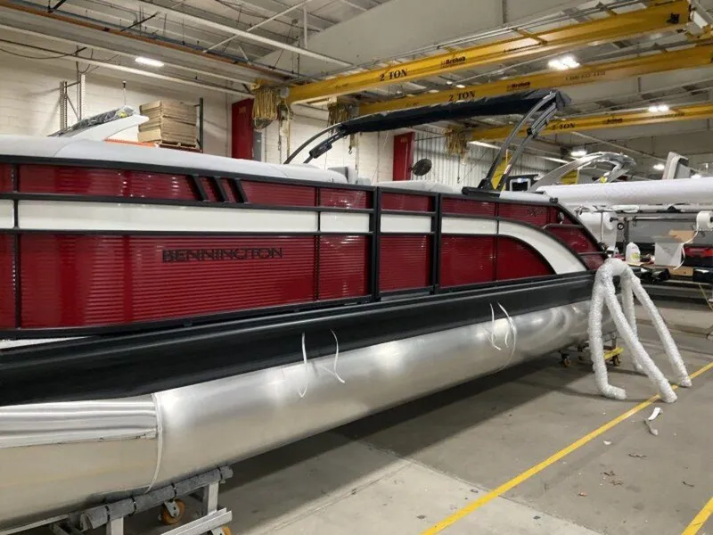 Slide: The Image of 2025 Bennington 24 SXSB pontoon boat in a warehouse setting. - 10