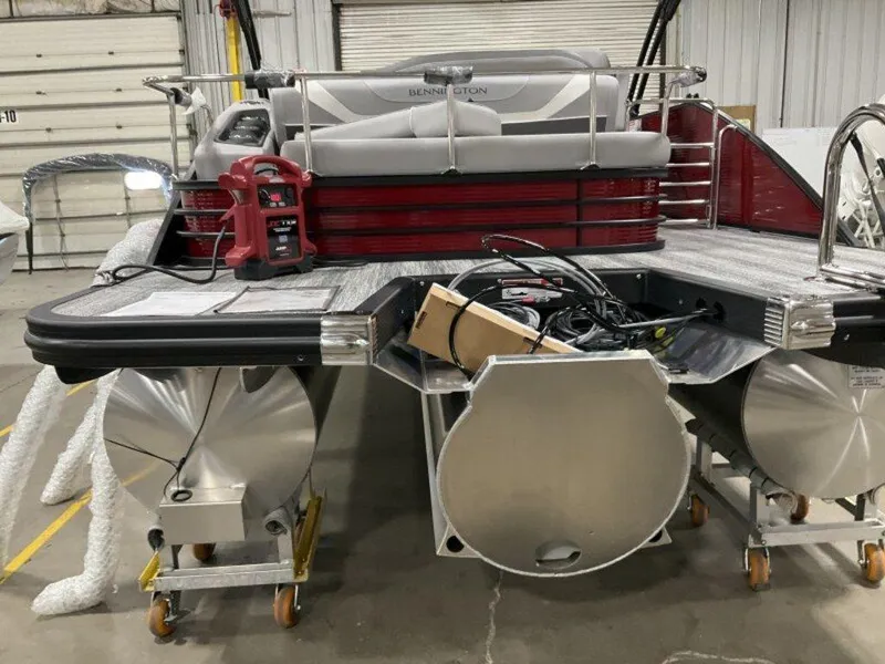 Slide: The Image of 2025 Bennington 24 SXSB pontoon boat in a garage, showcasing rear view and engine area. - 17