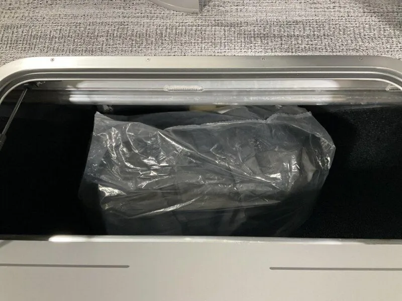 Slide: The Image of Storage compartment of 2025 Bennington 24 SXSB boat with plastic-covered item inside. - 21
