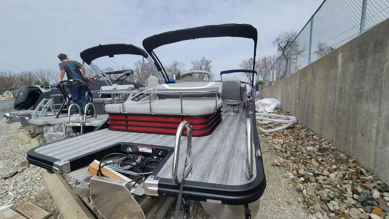 Slide: The Image of 2025 Bennington 24 SXSB pontoon boat with sleek design and modern features, docked outdoors. - 22