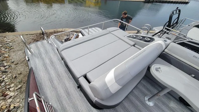Slide: The Image of 2025 Bennington 24 SXSB pontoon boat with spacious seating and modern design at a dock. - 3