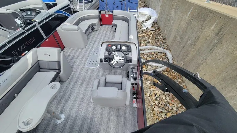 Slide: The Image of 2025 Bennington 24 SXSB boat interior with modern seating and steering console. - 6
