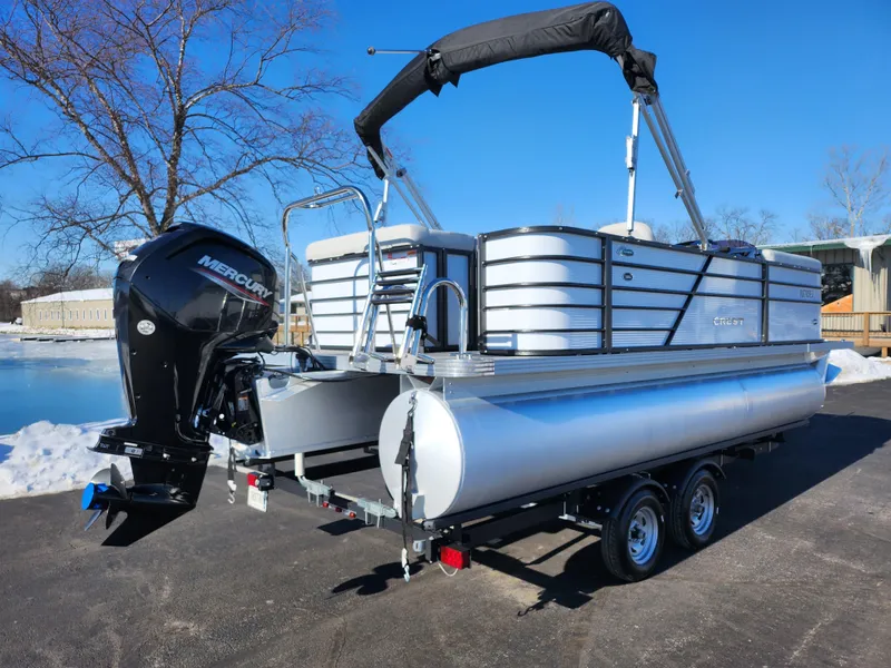 Slide: The Image of 2022 Crest Classic LX 200 pontoon boat on trailer, featuring a Mercury outboard motor. - 1