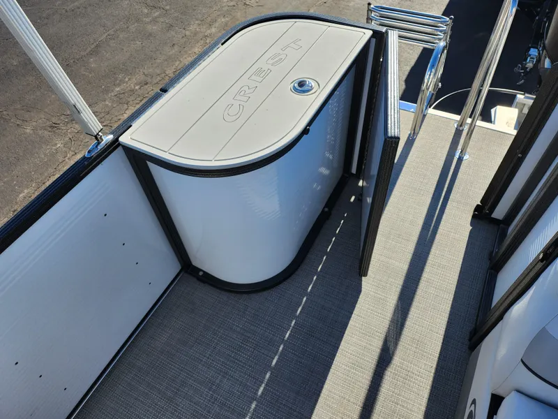 Slide: The Image of 2022 Crest Classic LX 200 boat interior with storage compartment and carpeted floor. - 15