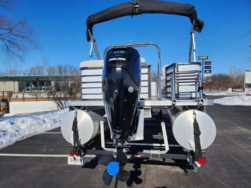 Slide: The Image of 2022 Crest Classic LX 200 pontoon boat with outboard motor, parked on snowy pavement. - 2