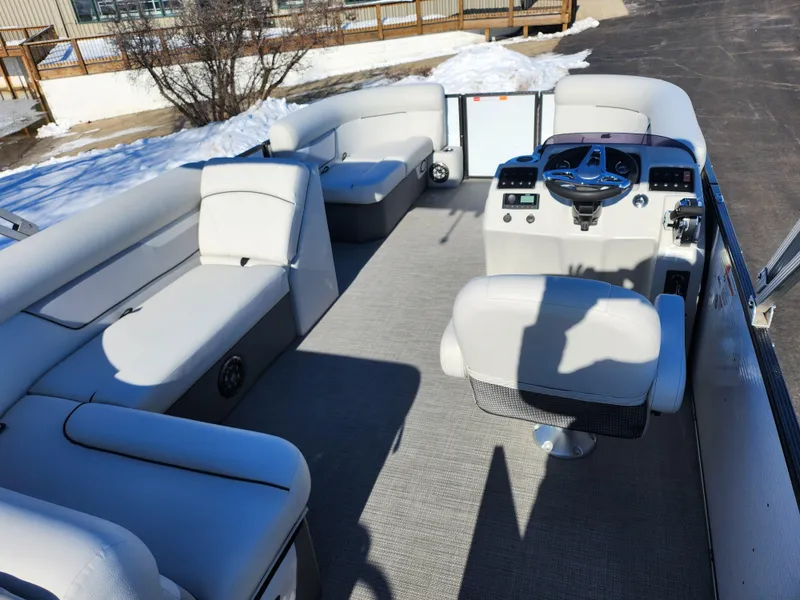 Slide: The Image of 2022 Crest Classic LX 200 pontoon boat interior with plush seating and modern helm. - 21