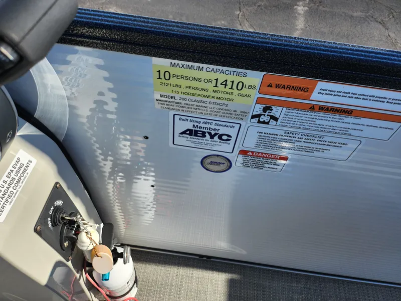 Slide: The Image of Capacity and warning labels on 2022 Crest Classic LX 200 boat dashboard. - 23