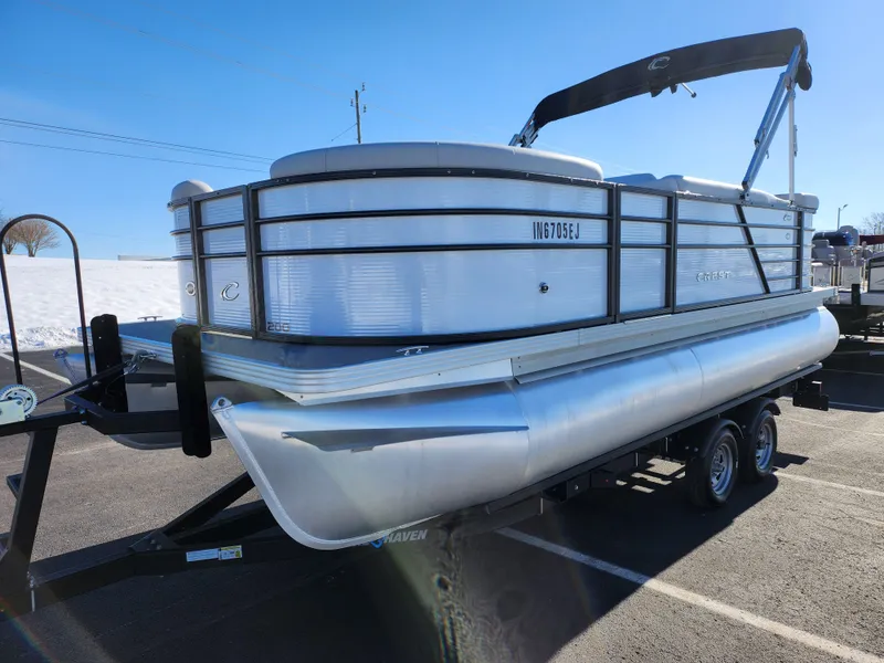 Slide: The Image of 2022 Crest Classic LX 200 pontoon boat on trailer, parked in a sunny lot. - 5