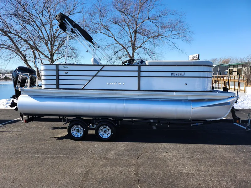 Slide: The Image of 2022 Crest Classic LX 200 pontoon boat on trailer, parked outdoors. - 9