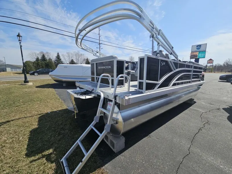 Slide: The Image of 2025 Bennington 188 SL pontoon boat with sleek design, parked outdoors on a sunny day. - 8