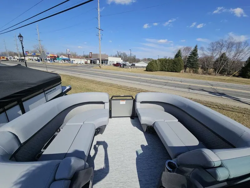 Slide: The Image of 2025 Bennington M Quad Bench 22 MFB pontoon boat with spacious seating, parked outdoors. - 3