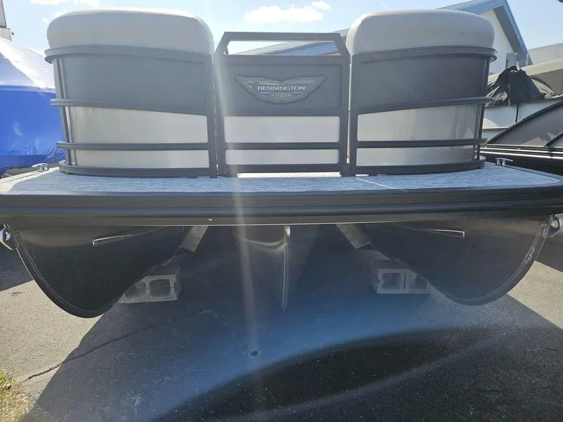 Slide: The Image of 2025 Bennington M Quad Bench 22 MFB pontoon boat, front view, parked on pavement. - 5