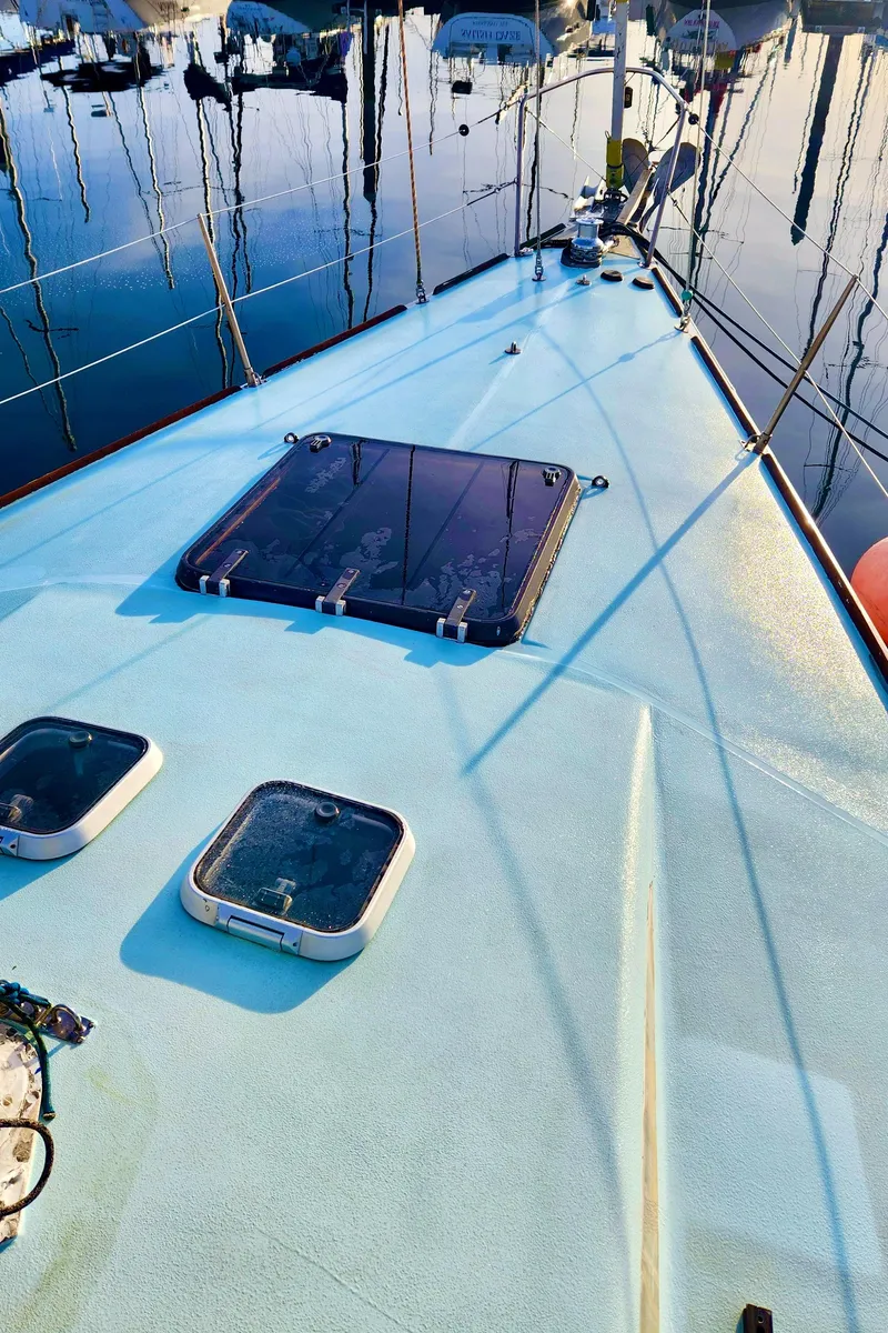 Slide: The Image of 1985 Farr 50 sailboat deck with hatches, docked in a marina. - 10