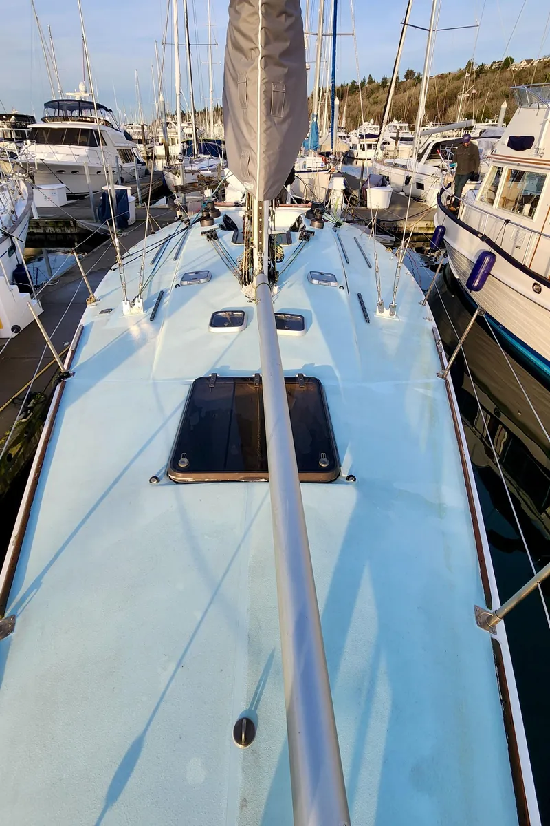Slide: The Image of 1985 Farr 50 sailboat deck view in marina, surrounded by other boats. - 12