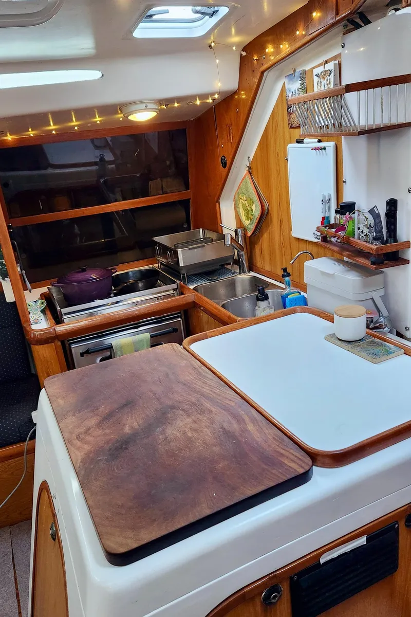 Slide: The Image of Cozy kitchen area in a 1985 Farr 50 yacht with wooden accents and modern amenities. - 17