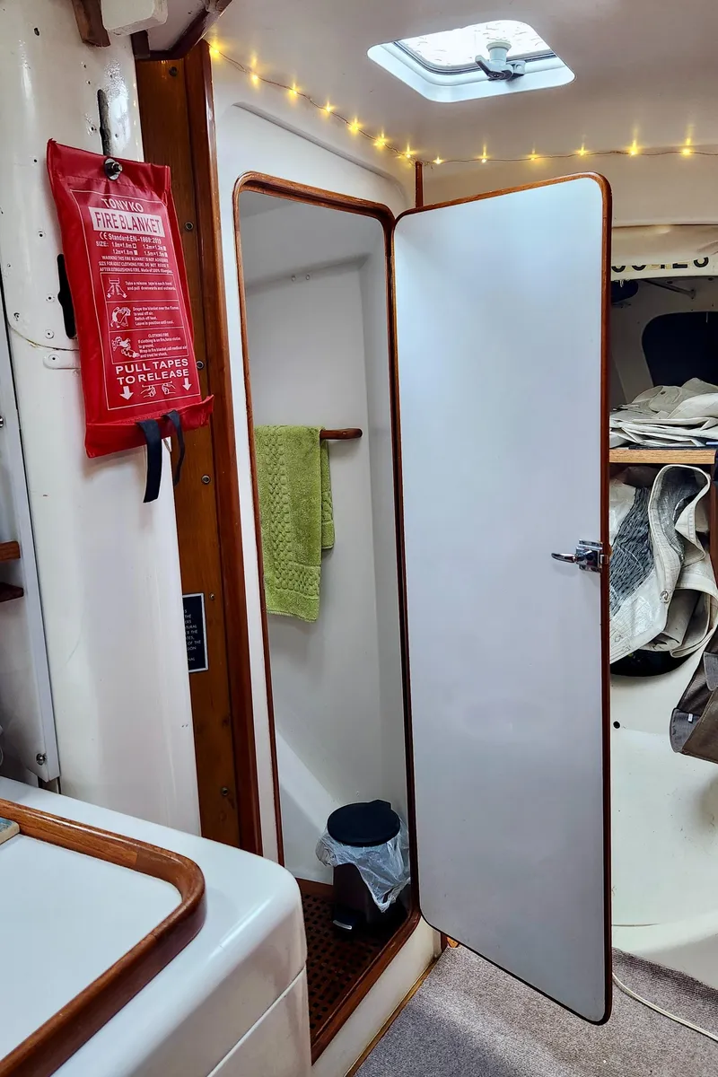 Slide: The Image of Interior of a 1985 Farr 50 yacht with open door, fire extinguisher, and cozy lighting. - 18