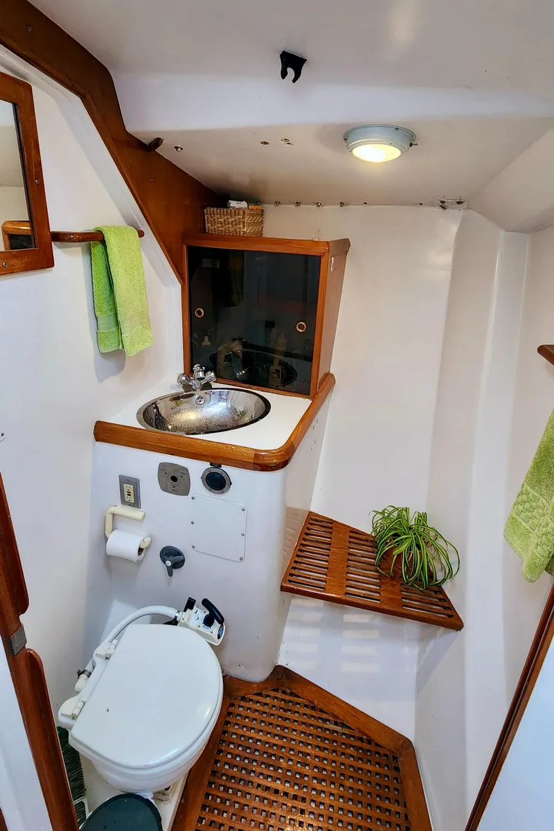 Slide: The Image of Compact bathroom in a 1985 Farr 50 yacht, featuring wooden accents and modern fixtures. - 21
